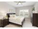 Cozy bedroom with natural light, a ceiling fan, a queen bed with decorative pillows, and neutral colored walls at 5250 Briarstone Ridge Way, Alpharetta, GA 30022