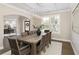 Open-concept dining room with stylish chandelier, large windows, and seamless flow into the living spaces at 5250 Briarstone Ridge Way, Alpharetta, GA 30022