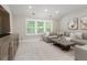 Comfortable living room featuring a sectional sofa, a modern coffee table, a TV console, and neutral carpet and walls at 5250 Briarstone Ridge Way, Alpharetta, GA 30022
