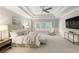 Spacious main bedroom featuring a tray ceiling, ceiling fan, and an abundance of natural light at 5250 Briarstone Ridge Way, Alpharetta, GA 30022