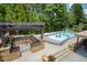 Community pool with splash pad, lounge chairs, a pergola and outdoor kitchen with stone accents at 5250 Briarstone Ridge Way, Alpharetta, GA 30022