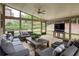 Inviting screened porch featuring comfortable seating, ceiling fan and views of the lush, green backyard at 5250 Briarstone Ridge Way, Alpharetta, GA 30022