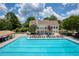 Resort-style swimming pool with numerous lounge chairs and umbrellas, surrounded by lush landscaping and clubhouse at 5250 Briarstone Ridge Way, Alpharetta, GA 30022
