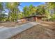 Concrete driveway leads to a charming brick home with a covered carport and wooded surroundings at 622 Saddlewood Dr, Lawrenceville, GA 30043