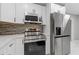Bright kitchen featuring stainless steel appliances, white cabinets, and contrasting backsplash at 622 Saddlewood Dr, Lawrenceville, GA 30043