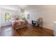 Bright bedroom with hardwood floors, a decorative light fixture, and a light green iron bed frame at 1200 Old Lathemtown Rd, Canton, GA 30115