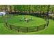 This outdoor area features a fire pit with chairs on green grass, surrounded by a wooden fence at 1200 Old Lathemtown Rd, Canton, GA 30115