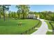 Stunning farmhouse on sprawling green lawn with fenced pasture and horses under a bright blue sky at 1200 Old Lathemtown Rd, Canton, GA 30115