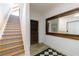 Hallway showcasing the staircase, a large mirror, and a dark wooden door at 1200 Old Lathemtown Rd, Canton, GA 30115