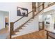 Open staircase featuring hardwood steps, metal cable railing, and natural light cascading through the foyer at 1200 Old Lathemtown Rd, Canton, GA 30115