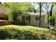 Blue home with cozy porch, mature trees, and a well-maintained lawn offering a welcoming curb appeal at 3043 Alston Dr, Decatur, GA 30032