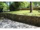 Front yard with stone retaining wall and mature trees at 3043 Alston Dr, Decatur, GA 30032