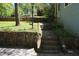 Stone walkway ascends to a home's entrance, bordered by a retaining wall and verdant greenery at 3043 Alston Dr, Decatur, GA 30032