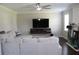 Spacious living room with ceiling fan, TV, white sofa, and fireplace at 3152 Spruce Way, Atlanta, GA 30349