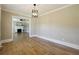 Dining room featuring hardwood floors and a modern light fixture with a glimpse into the living room at 785 Alice St, Forest Park, GA 30297