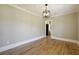 Dining room with hardwood floors featuring a modern light fixture, and adjacent kitchen at 785 Alice St, Forest Park, GA 30297