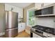 Modern kitchen featuring stainless steel appliances, including a refrigerator, microwave, and gas stove at 785 Alice St, Forest Park, GA 30297