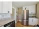 Modern kitchen with stainless steel refrigerator, granite countertops, and white cabinets at 785 Alice St, Forest Park, GA 30297