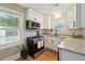 Bright kitchen with white cabinets, granite countertops, a stainless steel microwave, and a gas stove at 785 Alice St, Forest Park, GA 30297