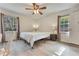 Sunlit bedroom featuring wood floors, large windows, neutral walls, and a ceiling fan at 1351 Stephens Sw St, Lilburn, GA 30047