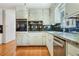 Kitchen featuring stainless steel appliances, white cabinets, and granite countertops at 1351 Stephens Sw St, Lilburn, GA 30047