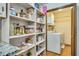View of the pantry with shelves of food and laundry room behind it at 1351 Stephens Sw St, Lilburn, GA 30047