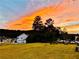 Sunset view of a spacious backyard and home with a swimming pool in the distance at 2127 Harmony Dr, Canton, GA 30115