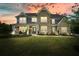 Beautiful two-story home featuring a brick facade, inviting front porch, and a well-manicured lawn at dusk at 2127 Harmony Dr, Canton, GA 30115