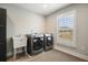 Laundry room features washer and dryer, utility sink, and window with shutters at 2127 Harmony Dr, Canton, GA 30115
