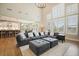 Open-concept living room with a large sectional sofa, tall windows, and seamless flow to the kitchen and dining area at 2127 Harmony Dr, Canton, GA 30115