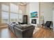 Cozy living room featuring a fireplace, large windows with shutters, and a comfortable gray sectional sofa at 2127 Harmony Dr, Canton, GA 30115
