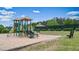 Community playground featuring modern play structures, surrounded by a sandpit, and grassy areas at 2127 Harmony Dr, Canton, GA 30115