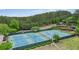 Aerial view showcases well-maintained community tennis courts with professional lighting and lush green surroundings at 2127 Harmony Dr, Canton, GA 30115