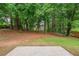 Expansive backyard featuring mature trees, providing shade and privacy, plus a small patio area at 4805 Wilkie Nw Way, Acworth, GA 30102