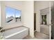 Well lit bathroom featuring a soaking tub and doorway leading to bedroom area at 4805 Wilkie Nw Way, Acworth, GA 30102