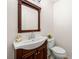 Powder room with dark wood vanity, white sink, and matching toilet for guest convenience at 4805 Wilkie Nw Way, Acworth, GA 30102