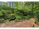 Serene backyard oasis with a wooden deck, mature landscaping, and a tranquil rock-lined pond at 2930 Winchester Dr, Cumming, GA 30041