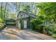 View of a house surrounded by trees, featuring a carport and a front door with greenery at 2930 Winchester Dr, Cumming, GA 30041