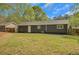 Large backyard with grass featuring a home with dark-toned exterior and fenced perimeter at 8833 E Bourne E Dr, Jonesboro, GA 30238
