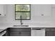Modern kitchen features stylish sink, quartz countertops, stainless steel dishwasher and dark-toned cabinetry at 8833 E Bourne E Dr, Jonesboro, GA 30238