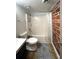 Bathroom featuring a modern toilet, tub/shower combo, with a brick accent wall detail at 172 Haynes Sw St # 107, Atlanta, GA 30313