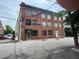 Exterior street view of a multi-story brick building featuring a 'Lofts' sign and street parking at 172 Haynes Sw St # 107, Atlanta, GA 30313