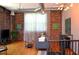 Stylish living room featuring exposed brick, an industrial ceiling, hardwood floors, and a cozy sofa at 172 Haynes Sw St # 107, Atlanta, GA 30313