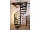 Metal spiral staircase connecting floors with a bookcase nearby at 172 Haynes Sw St # 107, Atlanta, GA 30313