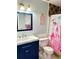 A charming bathroom with blue vanity, commode, and a princess themed shower curtain at 2536 Caray Ne Ct, Lawrenceville, GA 30043