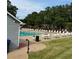 Outdoor pool area with tables, chairs, and umbrellas surrounded by lush green grass at 2536 Caray Ne Ct, Lawrenceville, GA 30043