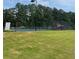 Well-maintained tennis court with a black fence, surrounded by lush green grass at 2536 Caray Ne Ct, Lawrenceville, GA 30043