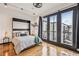Cozy bedroom features hardwood floors and balcony access through black framed glass doors at 5300 Peachtree Rd # 3601, Atlanta, GA 30341