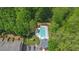 Community pool, playground, and parking area surrounded by lush greenery and mature trees at 1076 Firethorne Pass, Cumming, GA 30040