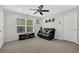 Bedroom with a ceiling fan, black leather couch, and a window letting in natural light at 1076 Firethorne Pass, Cumming, GA 30040